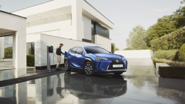 A man plugging in a charger into a Lexus UX 300e