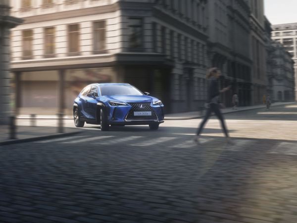 A Lexus UX 300e driving in a city location 