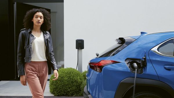 A woman next to a Lexus UX 300e