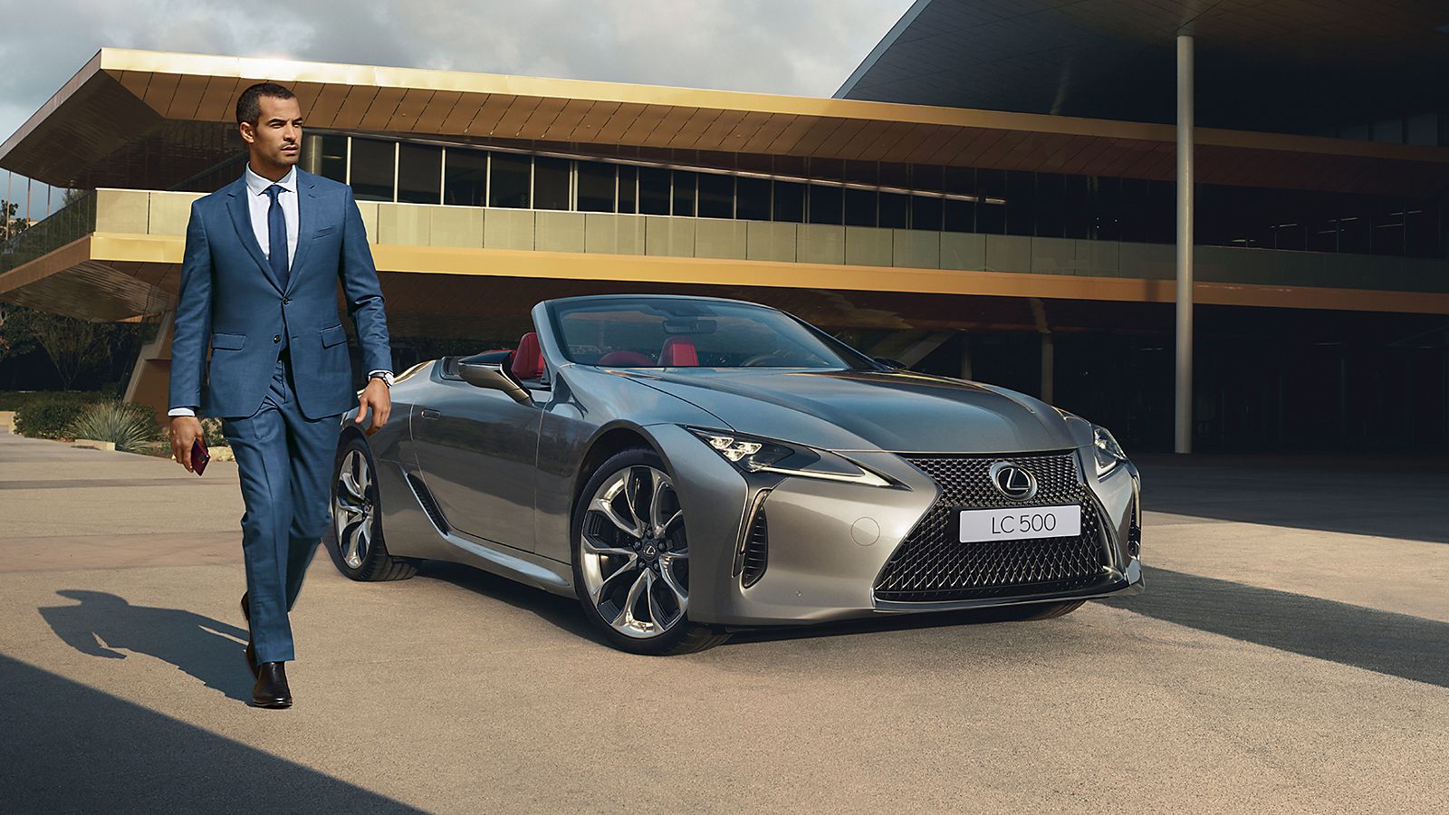 A man walking away from a Lexus LC Convertible
