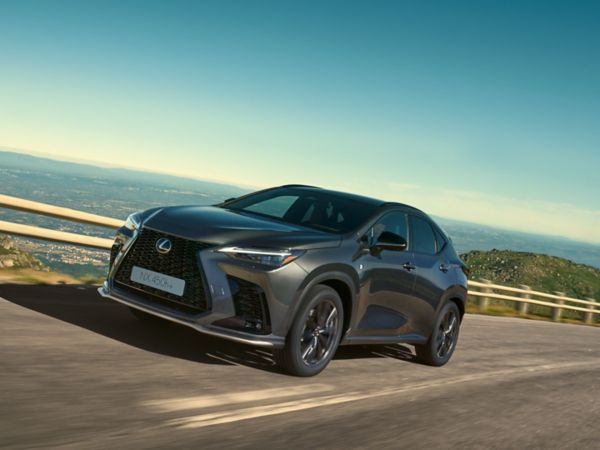 Un Lexus NX 450h+ grimpant une colline, mettant en valeur son design élégant.