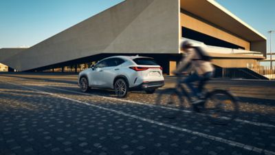 Ein Fahrrad fährt an einem geparkten Lexus vorbei