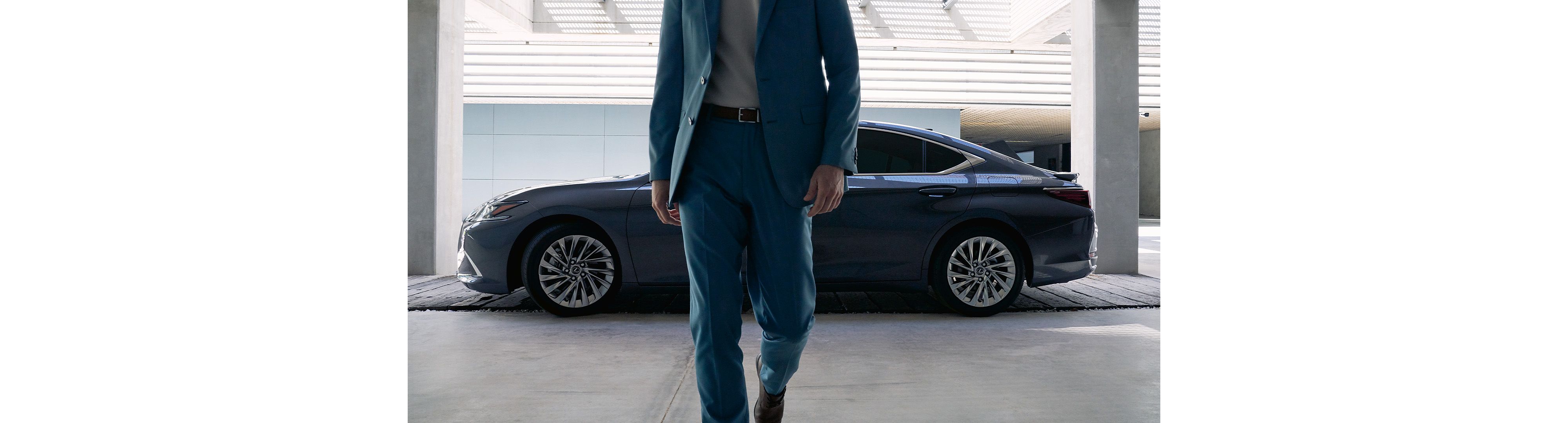 A man walking away from a parked Lexus ES