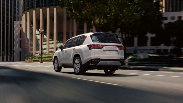 Rear view of a Lexus LX driving through a city location 