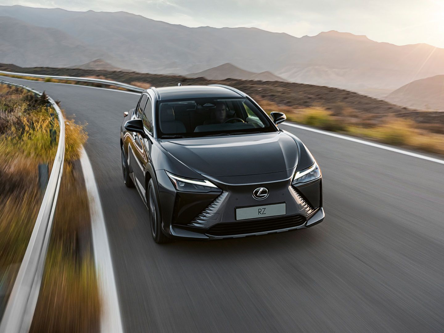 The Lexus RZ driving on a mountain road