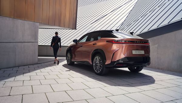 woman standing next to a Lexus car