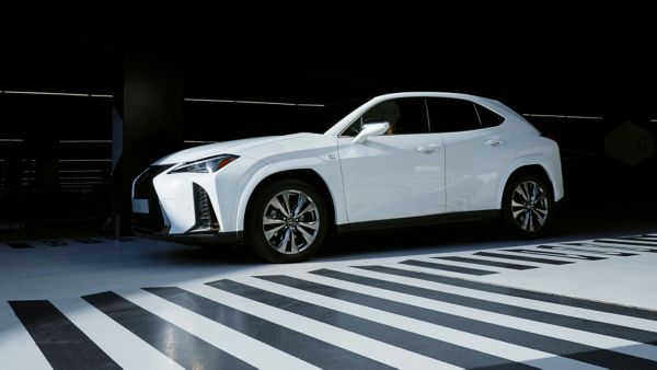 Een witte Lexus geparkeerd naast een vloer met zwart-wit patroon