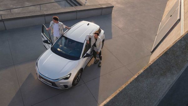 Two people outside a Lexus LBX