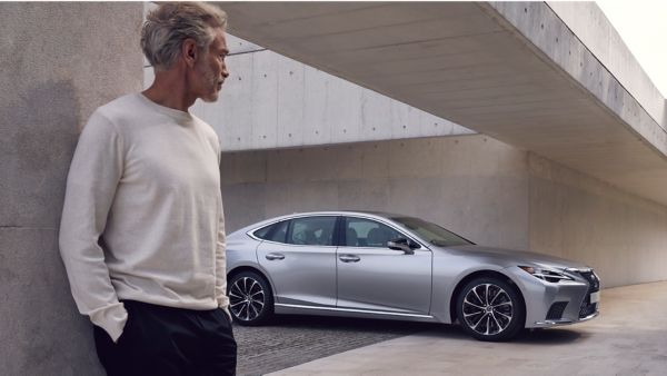 Mann steht vor einem Lexus