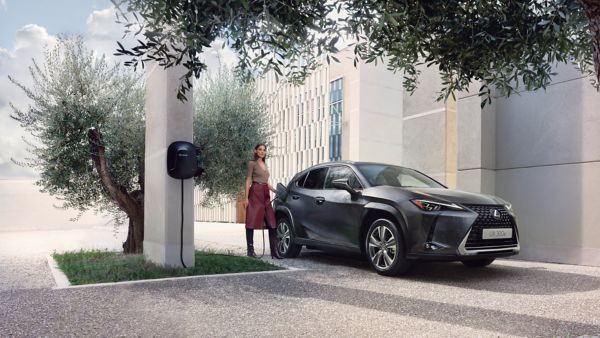 Eine Person schließt einen Lexus UX 300e an eine Ladestation an