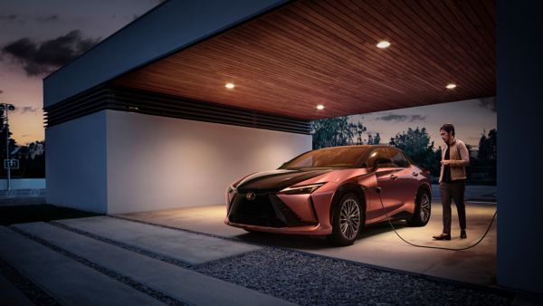 Een persoon die een stopcontact in een Lexus RZ 450e steekt