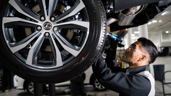 A mechanic inspecting a Lexus' undercarriage