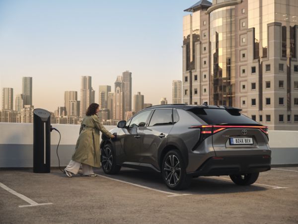 Une femme rechargeant sa voiture électrique - tvs