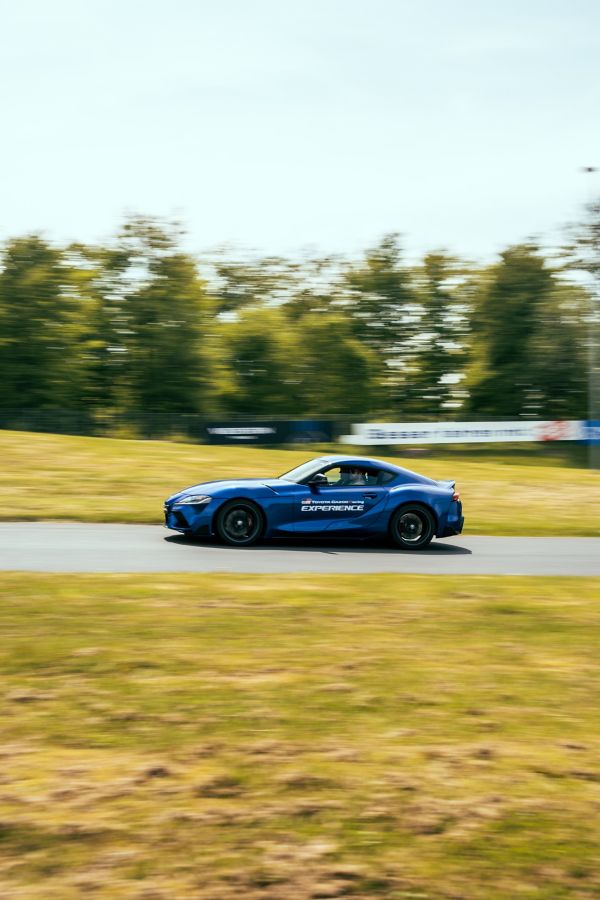 Ein blauer Sportwagen fährt schnell an der Kamera vorbei