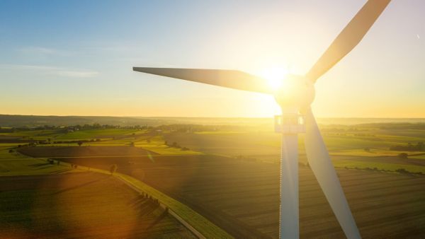 Windrad mit untergehender Sonne im Hintergrund