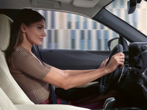 A driver with their hands on a Lexus steering wheel