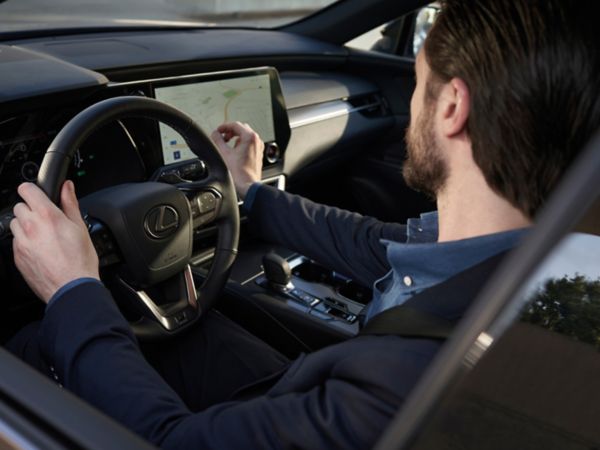 A driver with their hands on a Lexus steering wheel