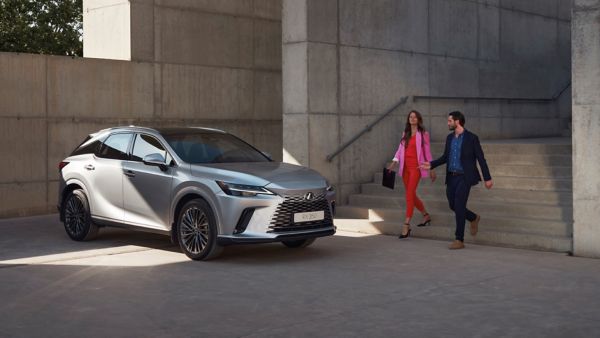 Two people walking towards a parked Lexus RX