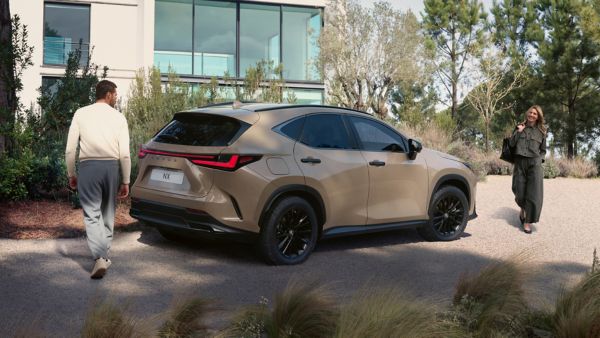 Two people walking near a Lexus