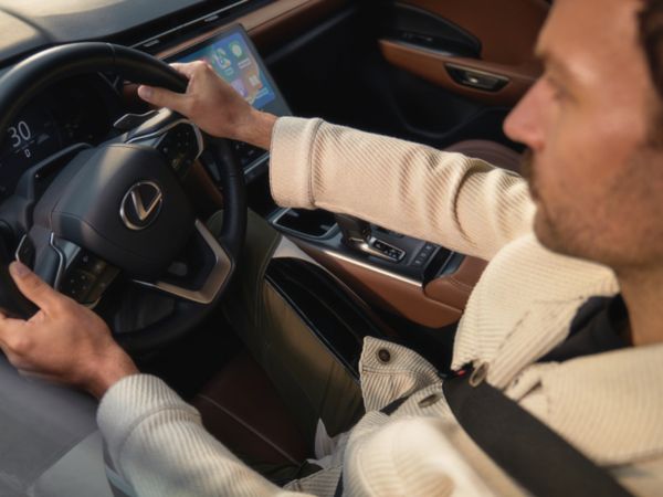 A driver with their hands on a Lexus steering wheel