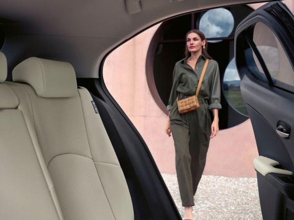 A person walking towards a Lexus