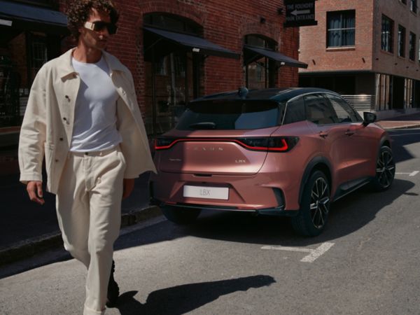 A person walking away from a parked Lexus RX