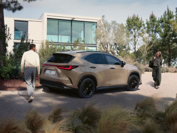 Two people walking towards a Lexus