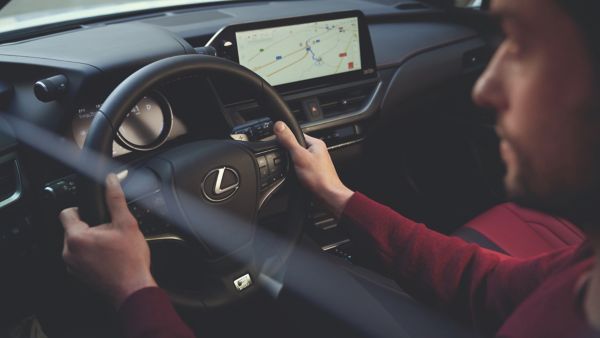 A driver with their hands on a Lexus steering wheel