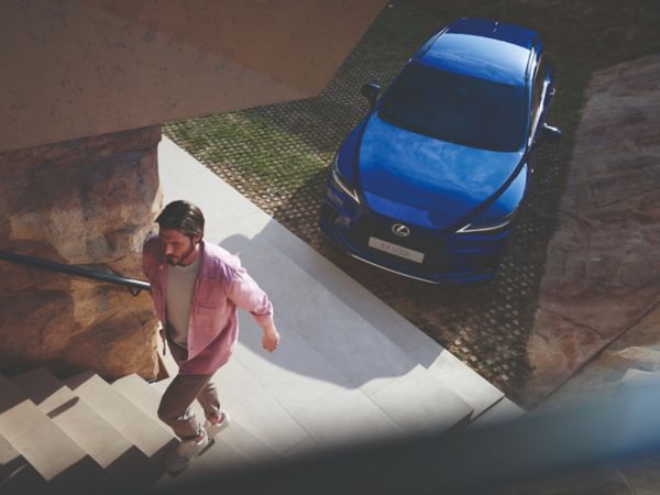 A person walking away from a parked Lexus RX
