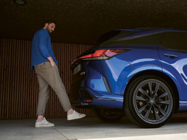 A person using the hands free boot on a Lexus