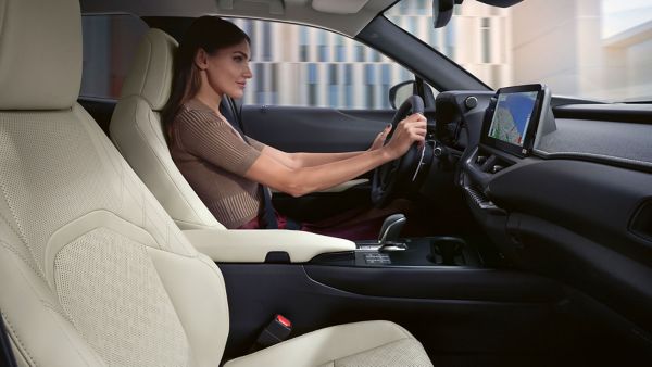 Eine Person sitz am Steuer eines Lexus und blickt entspannt auf die Straße vor sich