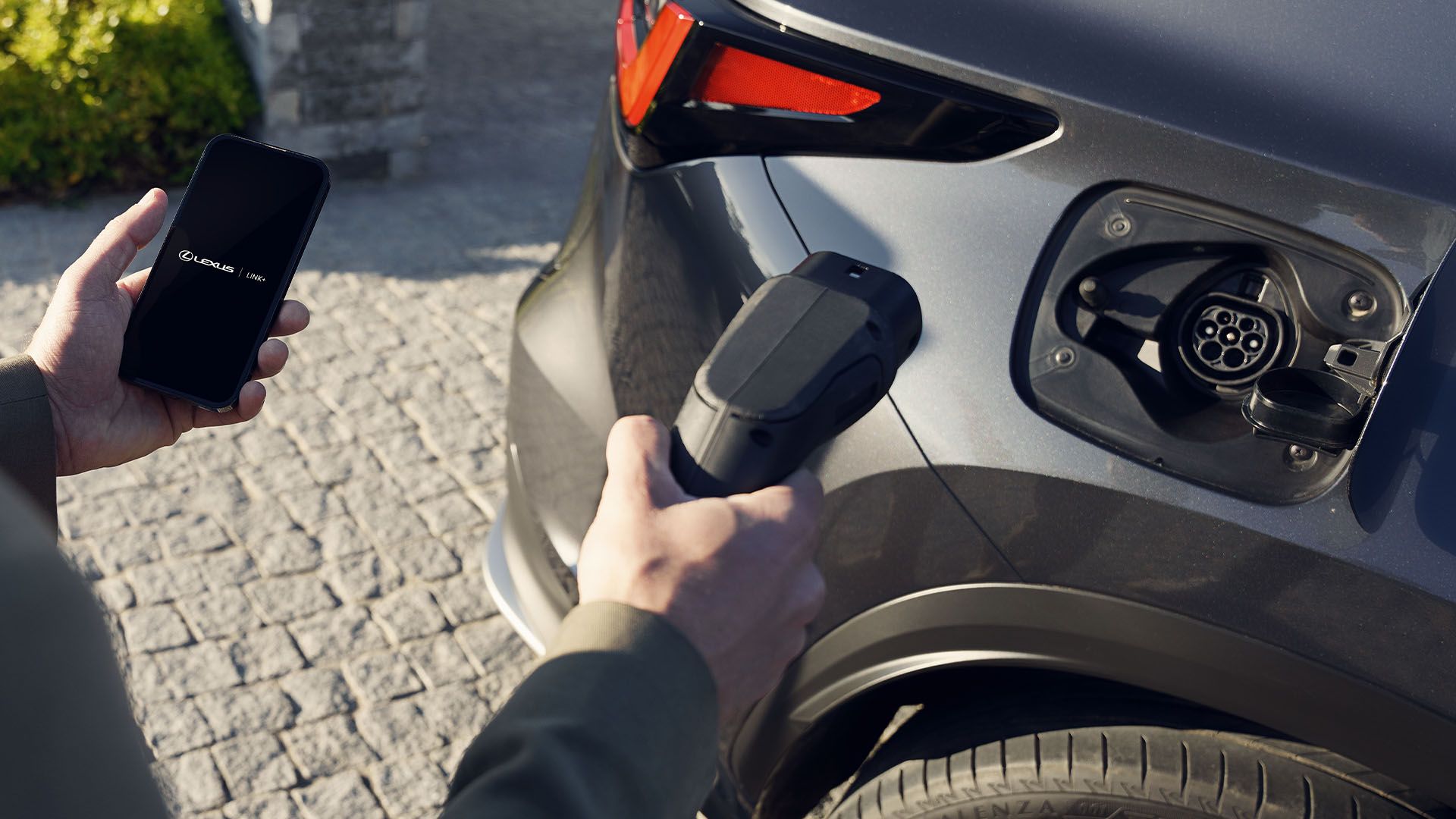 A person charging a plug-in hybrid Lexus