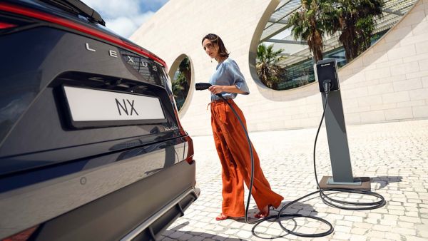 A person plugging in a charging socket into a Lexus NX