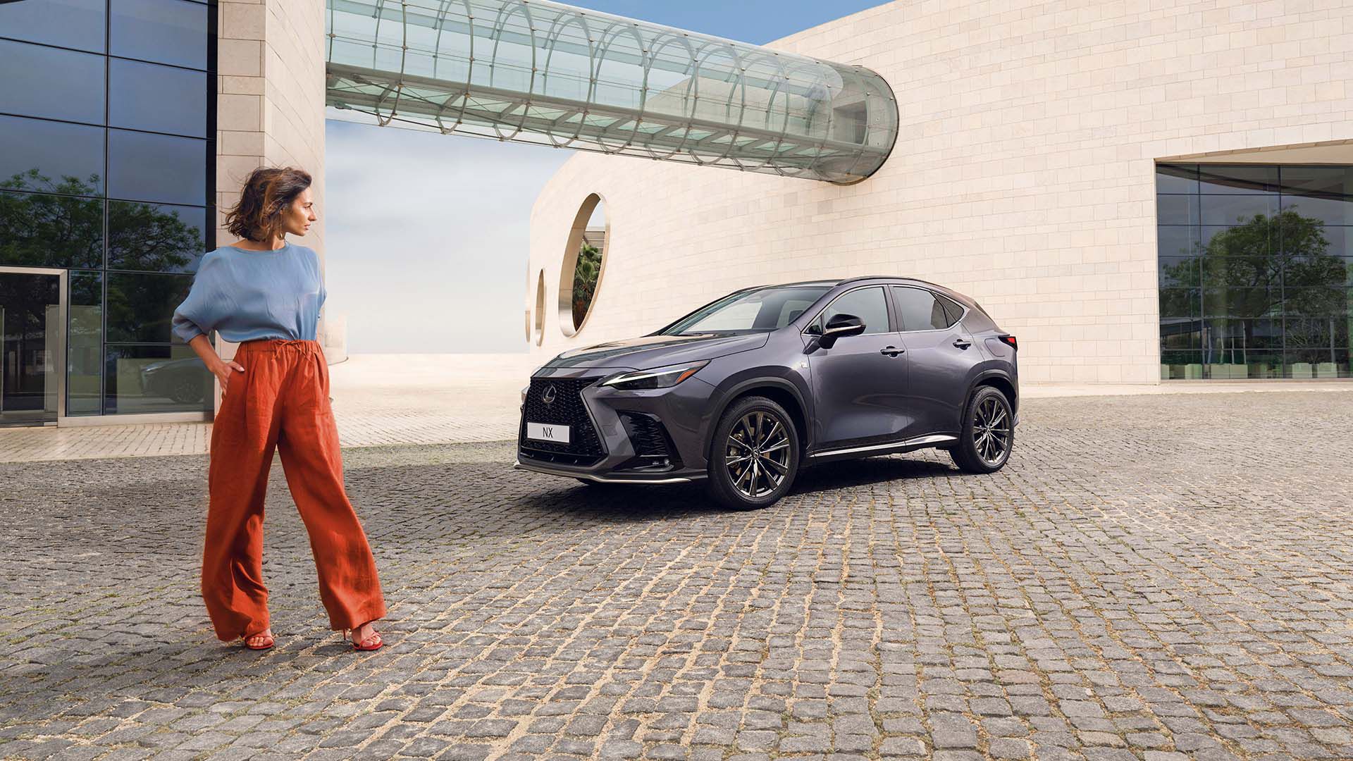 Eine Person sieht sich einen geparkten Lexus NX an.