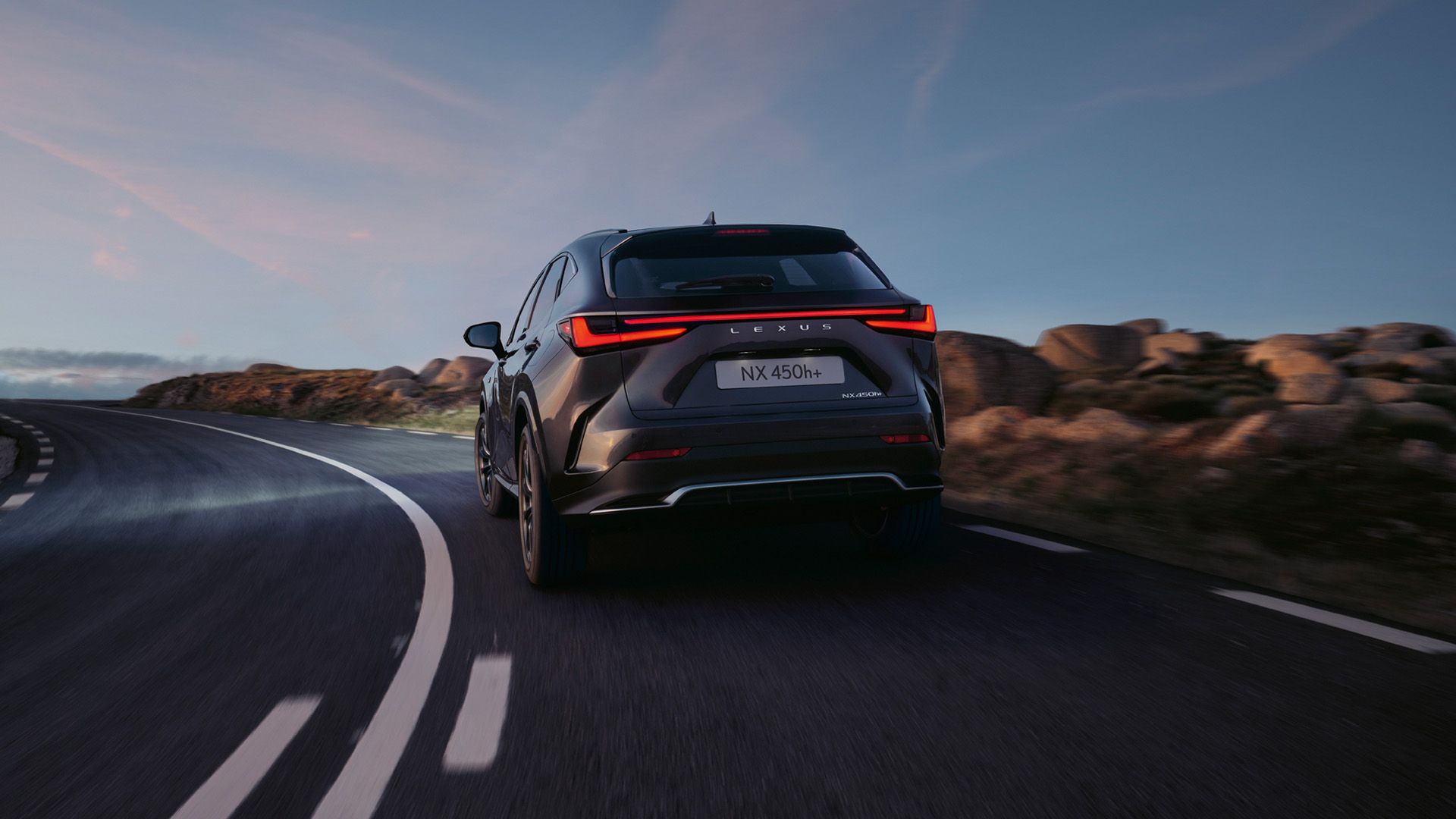  A Lexus NX 450h+ driving in a rural location