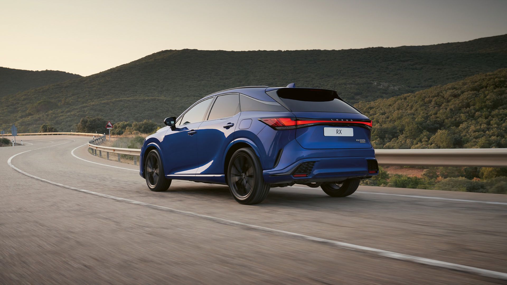 A Lexus RX driving on a road in a rural area