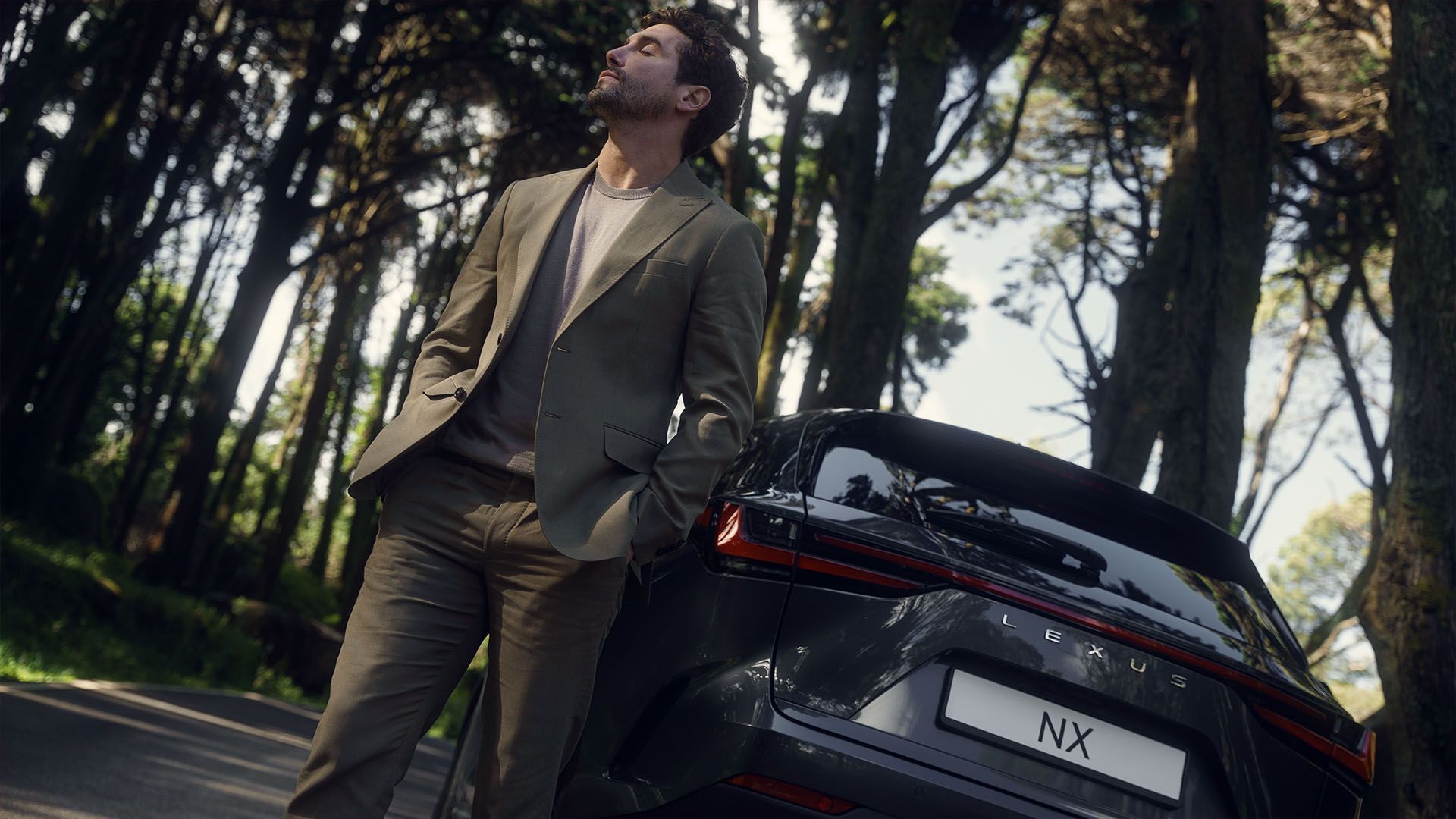 A person stood next to a Lexus NX in a woodland