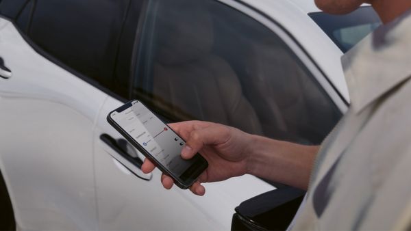 Osoba korzystająca z telefonu komórkowego w celu uzyskania dostępu do aplikacji Lexus Link+