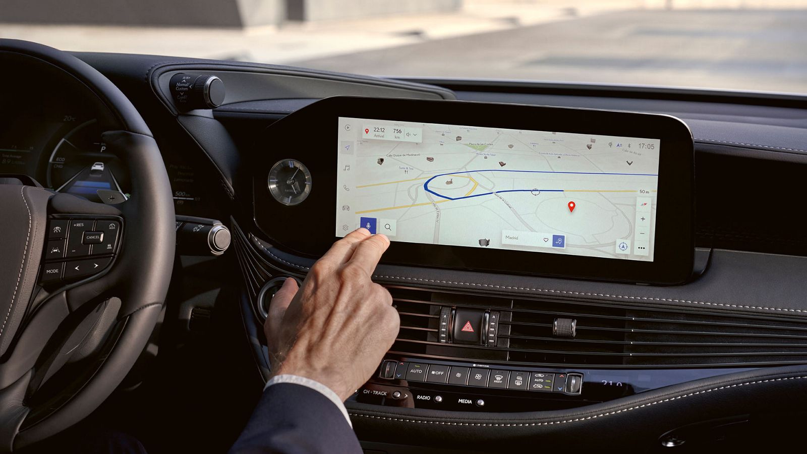 A driver interacting with a Lexus multimedia touchscreen