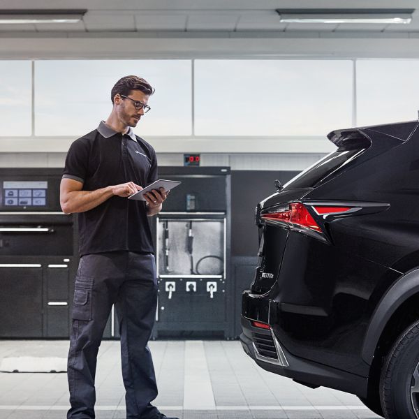 A mechanic next to a Lexus