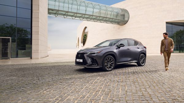 A person charging a Lexus NX using a charging box.