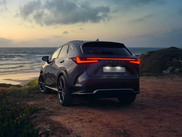 Ein Lexus NX parkt vor einem strand im Sonnenuntergang