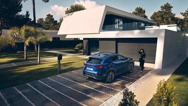 A parked Lexus NX 450h+ charging on a driveway