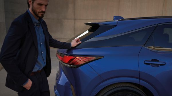 A man with his hand on the Lexus RX