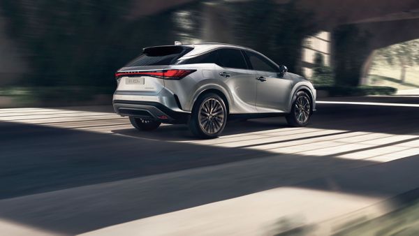 Zijaanzicht van een rijdende zilvere Lexus RX 450h+