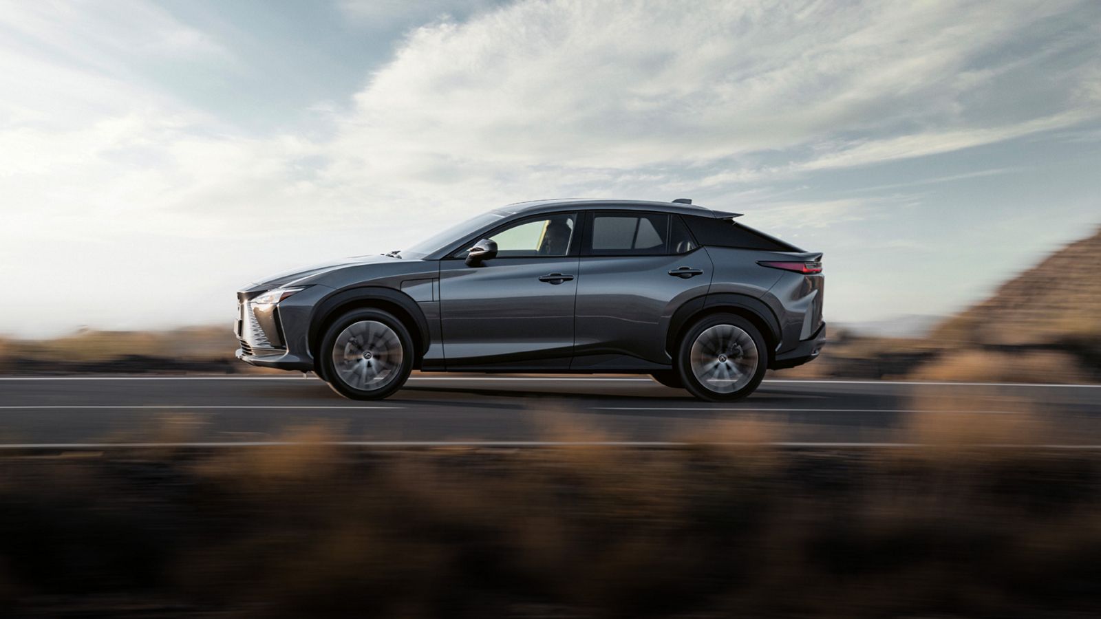 Lexus RZ driving on a scenic road