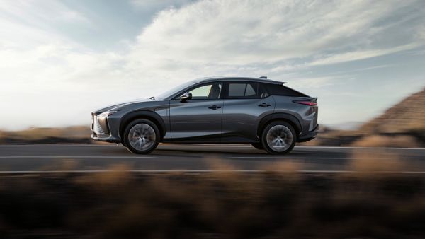 Der Lexus RX zeigt seine dynamische Seitenansicht, während er über eine Landstraße fährt.