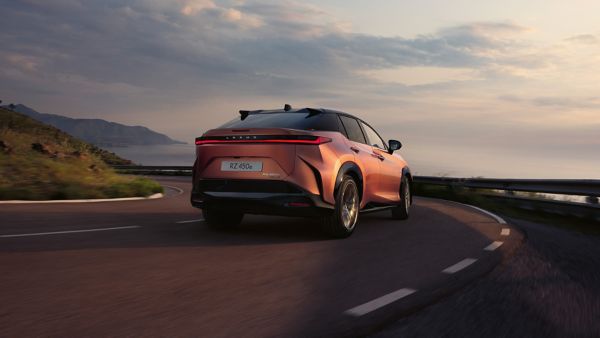 Rear view of the Lexus RZ 450e driving in a rural location