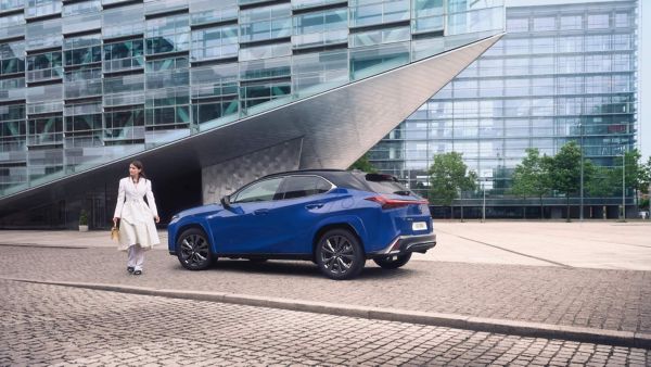 A person stood next to a blue Lexus UX