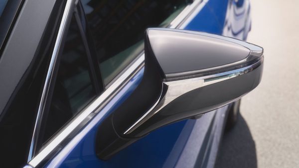 Nahaufnahme eines eleganten Lexus UX-Seitenspiegels mit schwarzer Hochglanzoberfläche und Chromverzierungen